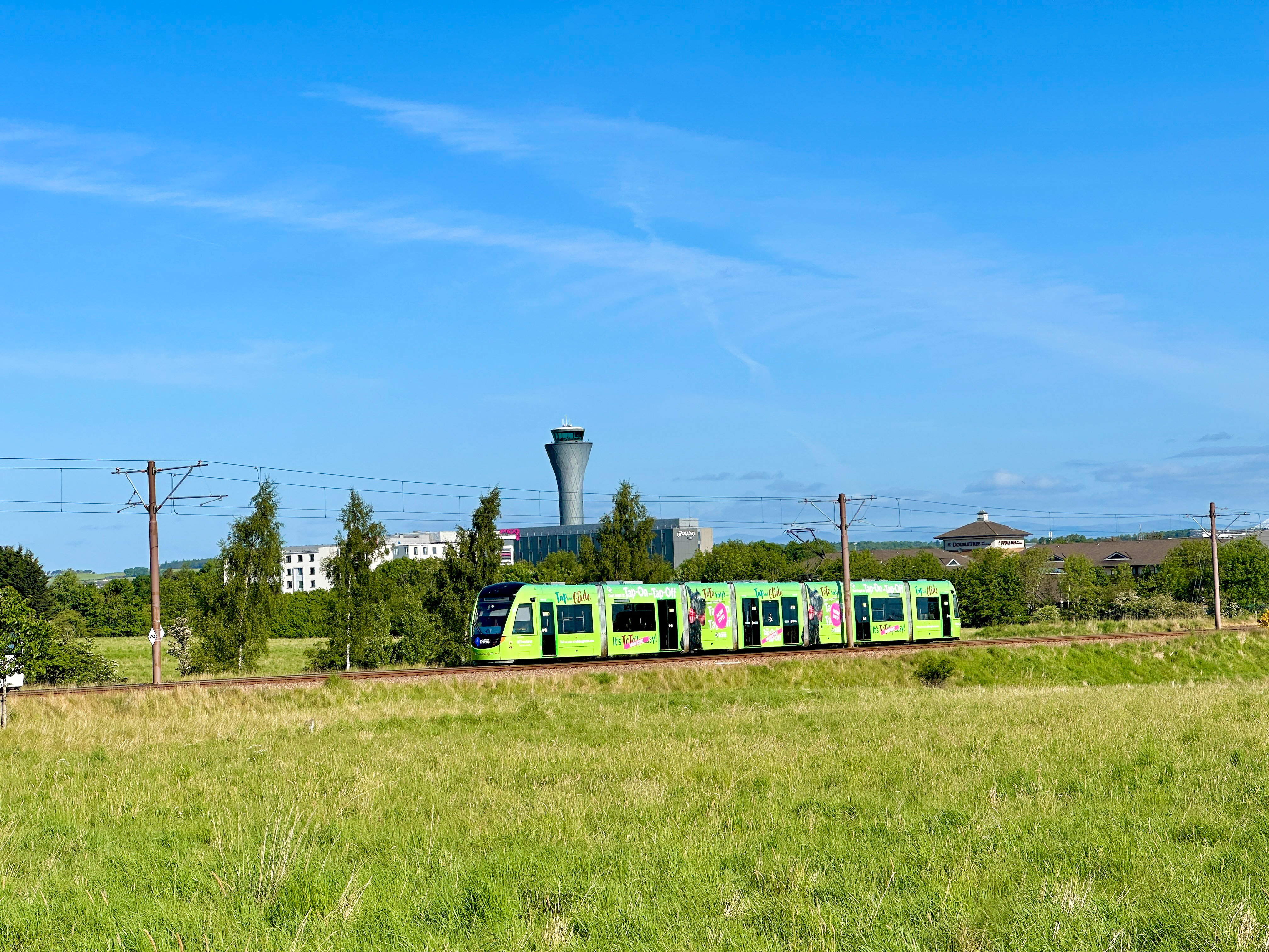 an image of a green tram against a blue sky background