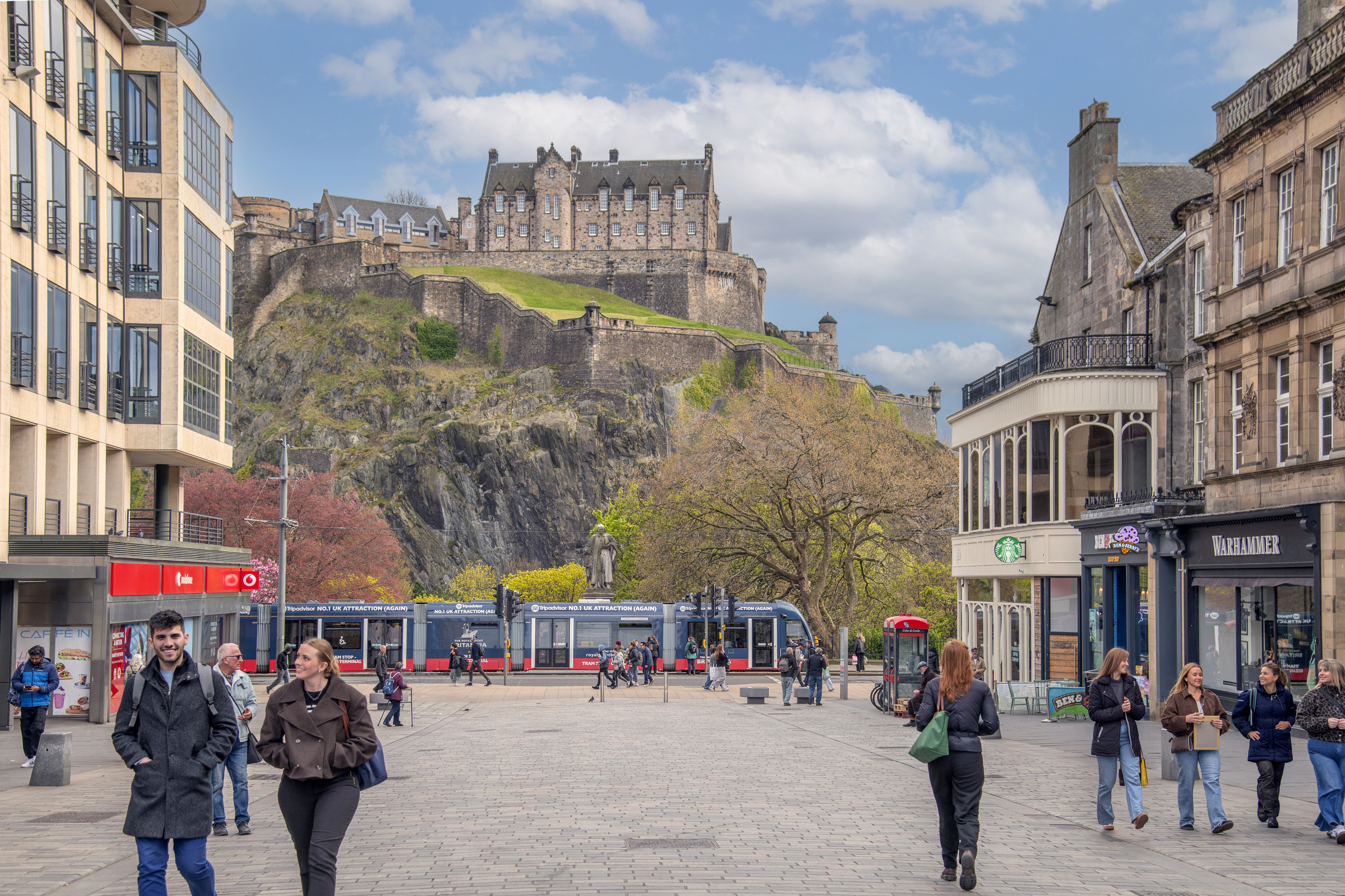 View of Edinburgh Castle and tram gliding down Princes Street as seen from Castle Street