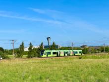 an image of a green tram against a blue sky background
