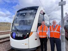 Ally and Jon standing next to a tram at the Edinburgh Trams depot