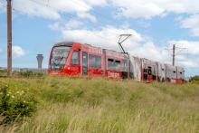 Edinburgh Trams tram with Edinburgh Airport in the background