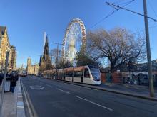 Tram on Princes Street with Edinburgh's Christmas in the background