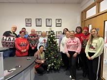 Edinburgh Trams colleagues in Christmas jumpers in front of a Christmas tree