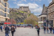 View of Edinburgh Castle and tram gliding down Princes Street as seen from Castle Street