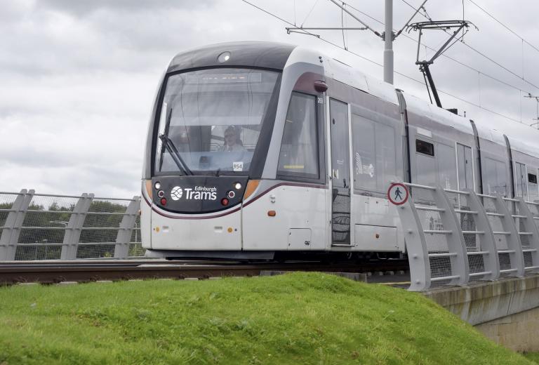 Tram on bridge with grass