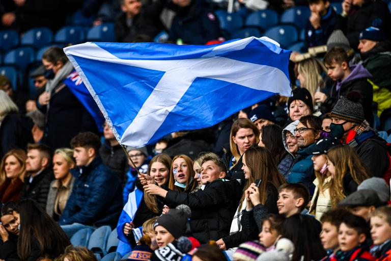 Crowd at a Scottish Rugby game holding a Scotland flag