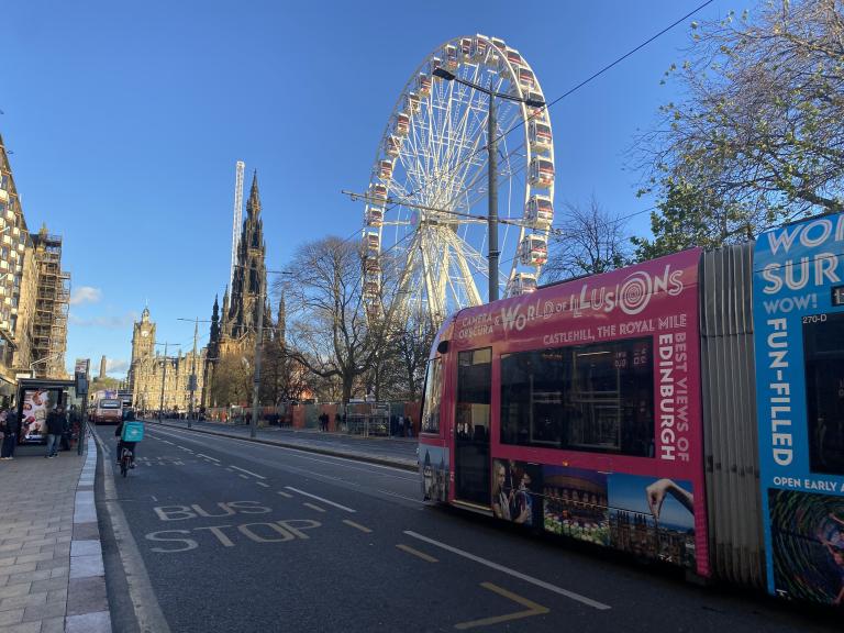 Tram on Princes Street with Edinburgh's Christmas in the background