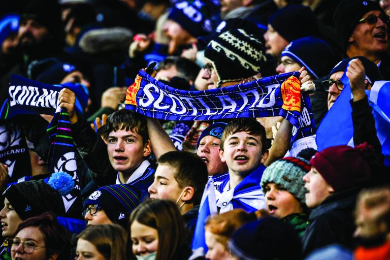 Fans at Murrayfield Stadium holding up Scotland scarf