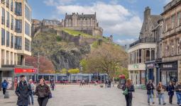 View of Edinburgh Castle and tram gliding down Princes Street as seen from Castle Street
