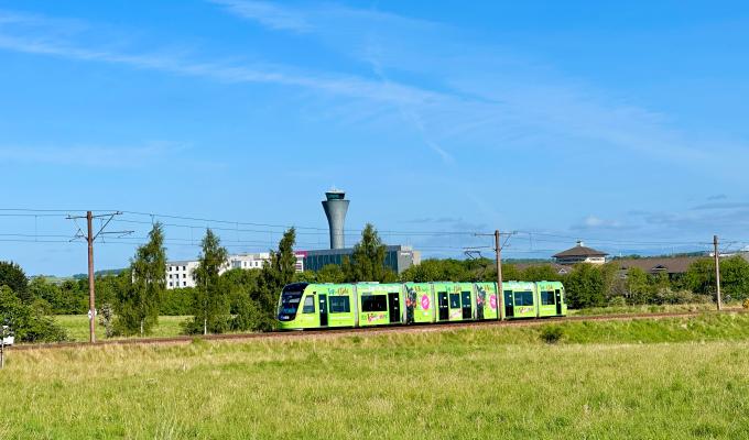 an image of a green tram against a blue sky background