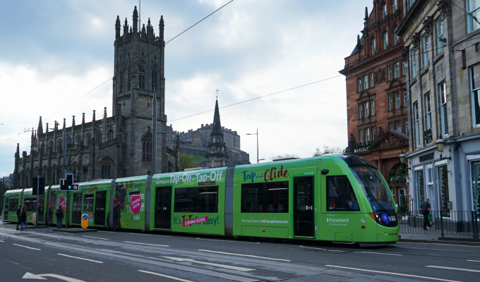 an image of the green 'Tap on, Tap off' tram in Edinburgh city centre, with 'coming soon' message applied.