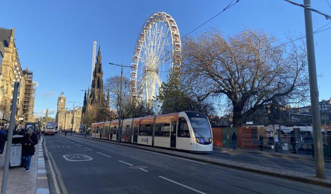 Tram on Princes Street with Edinburgh's Christmas in the background