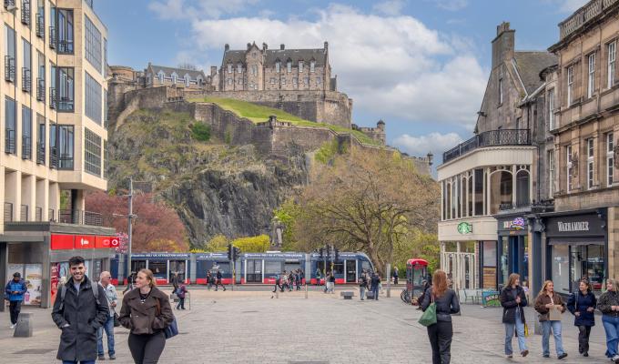 View of Edinburgh Castle and tram gliding down Princes Street as seen from Castle Street