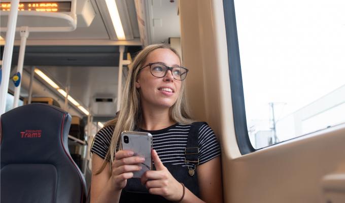 Girl holding phone on tram